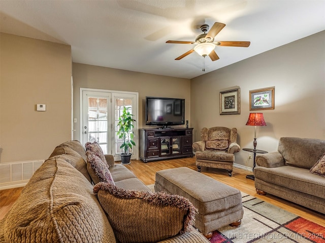 living area with visible vents, ceiling fan, light wood-style flooring, and baseboards