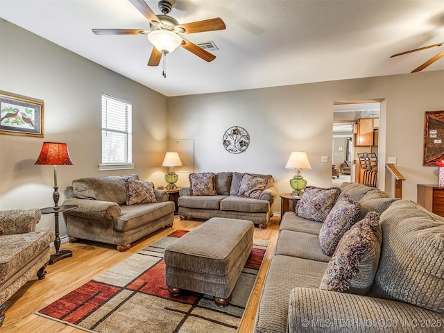 living area featuring ceiling fan, wood finished floors, and visible vents