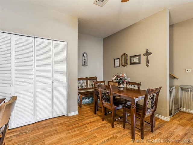 dining area featuring baseboards, visible vents, and light wood finished floors