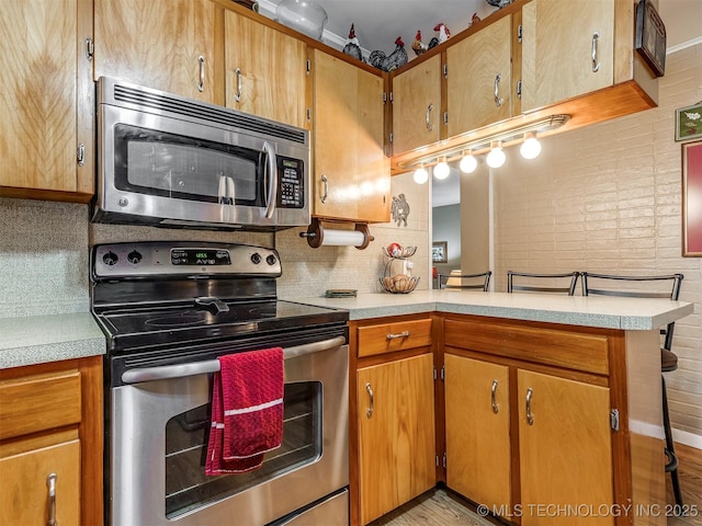 kitchen featuring appliances with stainless steel finishes, light countertops, and tasteful backsplash