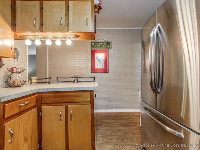 kitchen with baseboards, light countertops, wood finished floors, and freestanding refrigerator