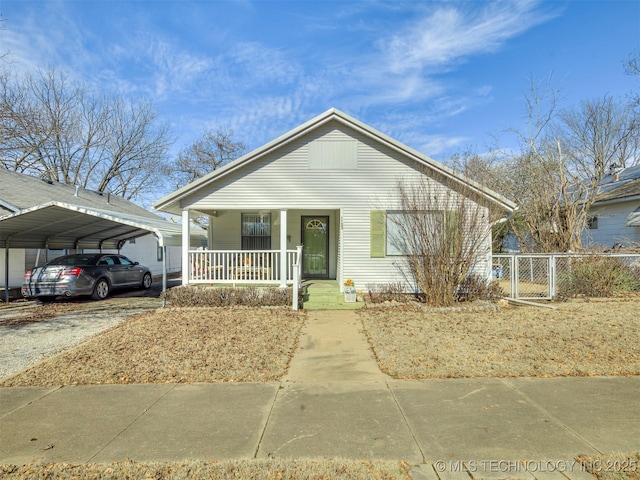 bungalow-style house featuring a carport, covered porch, and fence