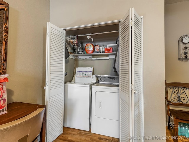 laundry room featuring laundry area, separate washer and dryer, and wood finished floors