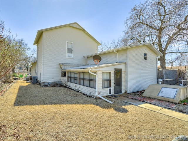 rear view of house featuring a yard, fence, and central AC unit