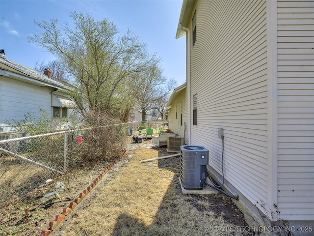 view of yard with fence and central air condition unit