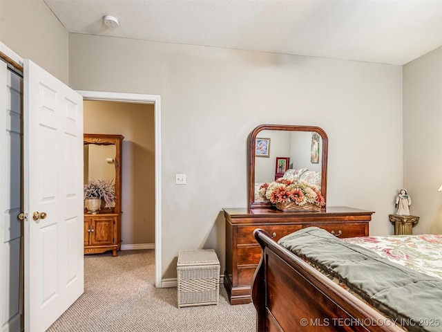 bedroom featuring light carpet and baseboards