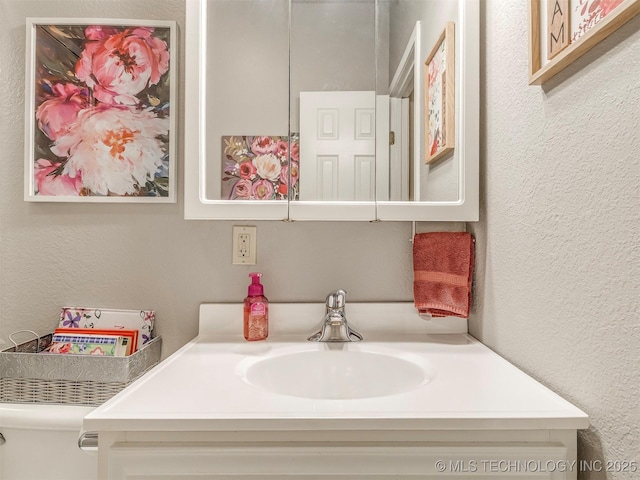 bathroom featuring a textured wall and vanity