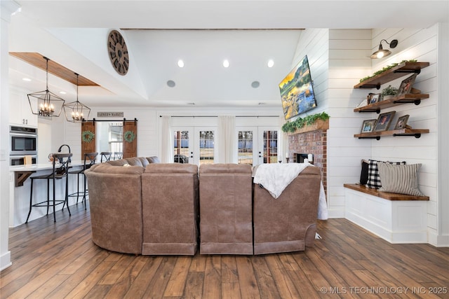 living room featuring a fireplace, dark wood finished floors, a raised ceiling, and french doors