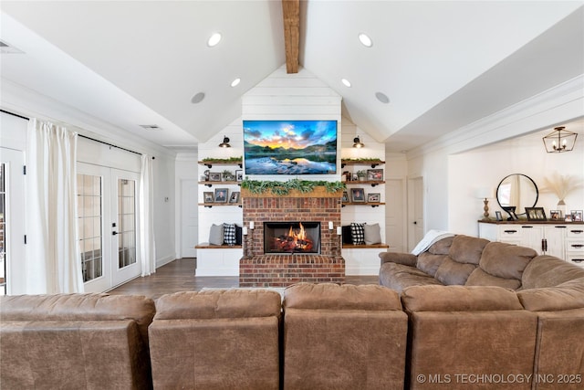 living area with french doors, visible vents, lofted ceiling with beams, a brick fireplace, and wood finished floors