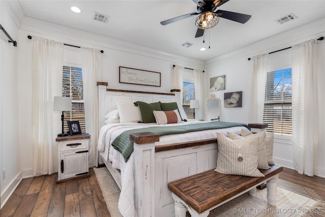 bedroom with ornamental molding, visible vents, and hardwood / wood-style flooring