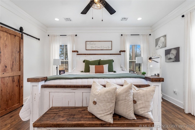 bedroom featuring visible vents, multiple windows, and a barn door