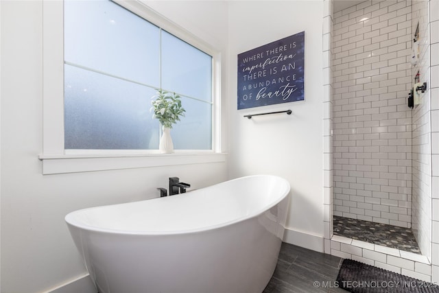 full bath with a freestanding bath, a shower stall, baseboards, and wood finished floors