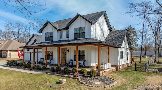 modern farmhouse with covered porch, fence, a gate, board and batten siding, and a front yard