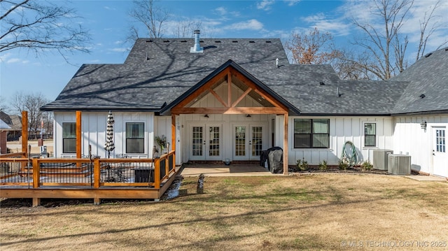 rear view of property featuring french doors, board and batten siding, a shingled roof, and a lawn