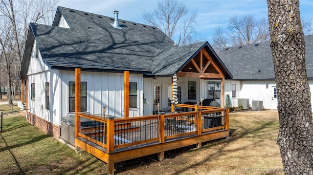 back of house featuring central air condition unit, a shingled roof, and a yard