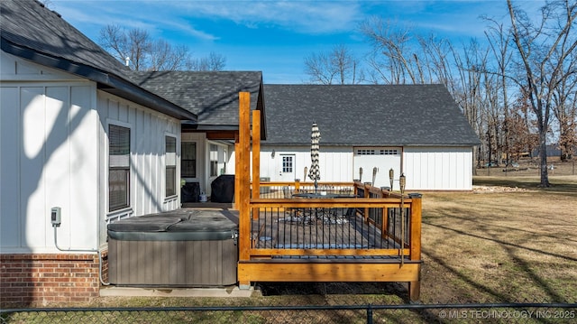 back of house featuring a hot tub, a deck, board and batten siding, and roof with shingles