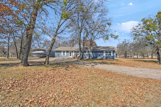 ranch-style home featuring driveway and a carport