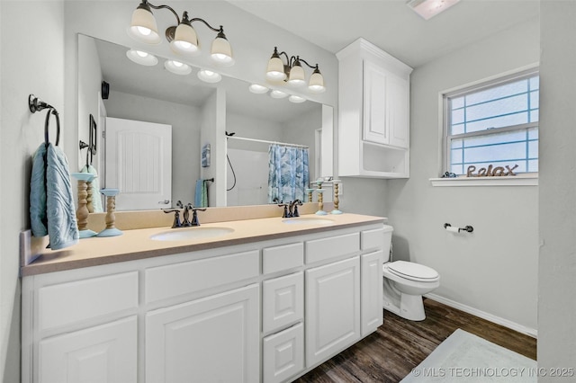 full bath featuring toilet, wood finished floors, a sink, a shower with curtain, and double vanity