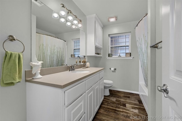 full bathroom featuring toilet, wood finished floors, a wealth of natural light, and vanity