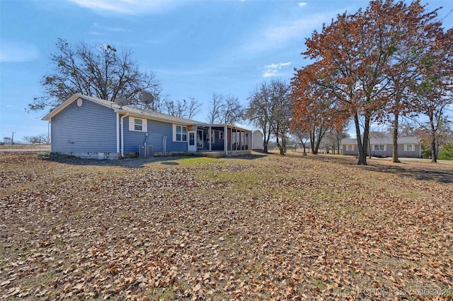 rear view of property with cooling unit and a sunroom