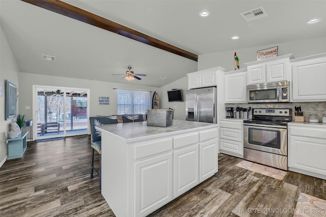 kitchen featuring lofted ceiling with beams, visible vents, appliances with stainless steel finishes, a center island, and tasteful backsplash