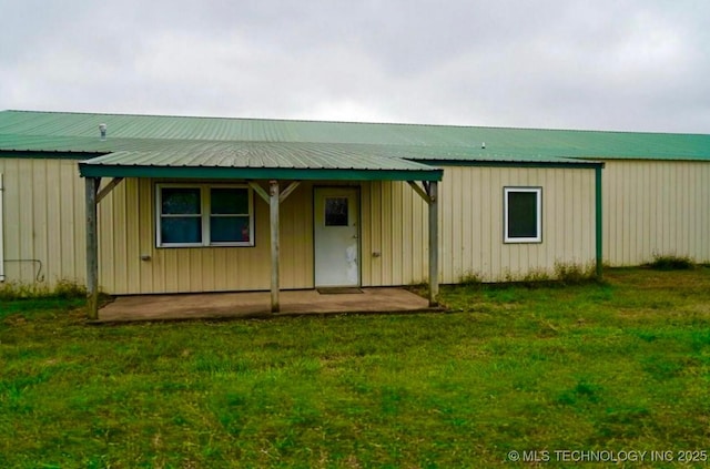 view of front of home featuring metal roof, board and batten siding, and a front yard