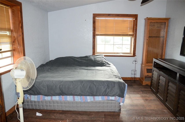 bedroom with baseboards and wood finished floors