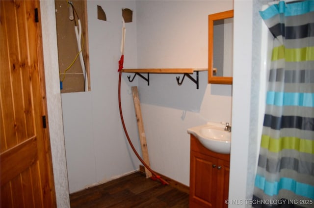 bathroom featuring curtained shower, wood finished floors, and vanity