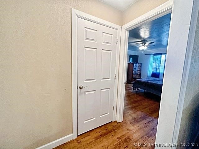 hall with wood finished floors and baseboards