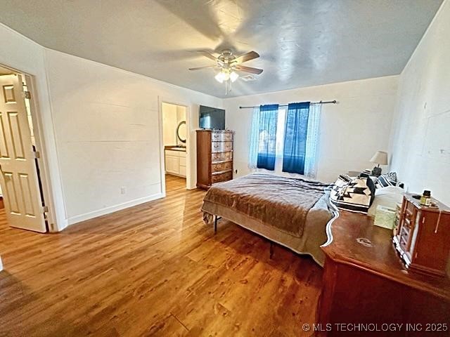 bedroom featuring ceiling fan, baseboards, and wood finished floors