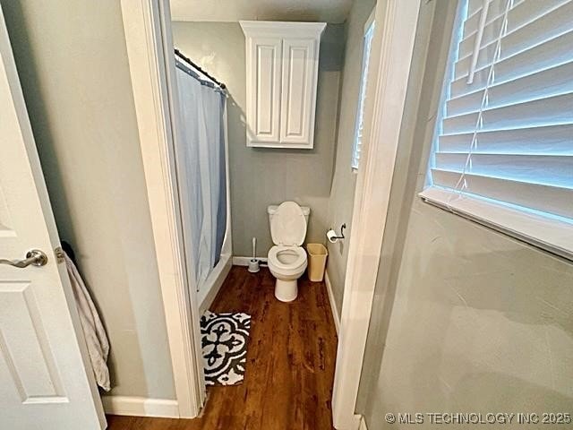 full bath with toilet, a shower with curtain, baseboards, and wood finished floors