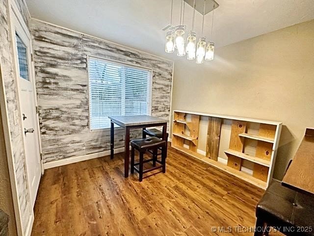 dining room with a chandelier, wood finished floors, and baseboards