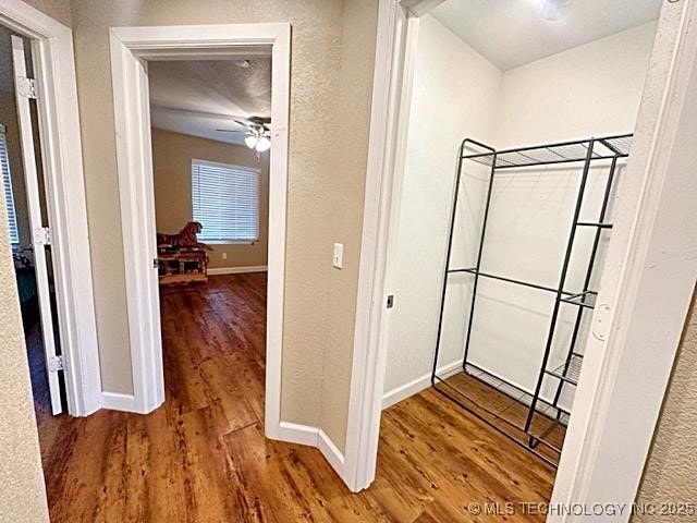 hallway with wood finished floors and baseboards