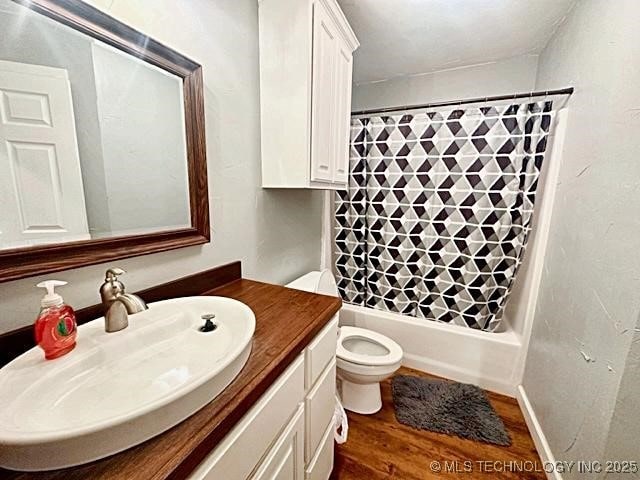 bathroom featuring shower / bath combo, vanity, toilet, and wood finished floors