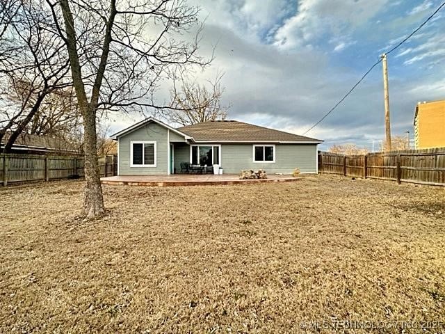 rear view of house with a patio and a fenced backyard