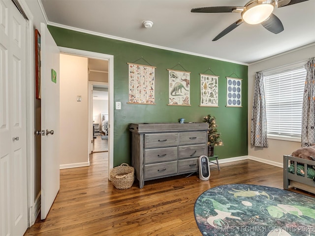 interior space featuring crown molding, baseboards, and wood finished floors