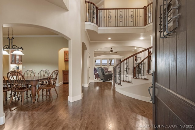 11870 S Oswego Ave, Tulsa, OK 74137 - entryway with ornamental molding, arched walkways, stairway, a ceiling fan, and wood finished floors