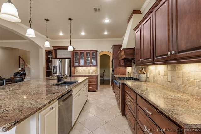 11870 S Oswego Ave, Tulsa, OK 74137 - kitchen featuring arched walkways, appliances with stainless steel finishes, a sink, backsplash, and crown molding