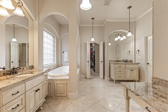 11870 S Oswego Ave, Tulsa, OK 74137 - bathroom featuring a garden tub, two vanities, ornamental molding, tile patterned floors, and a walk in closet