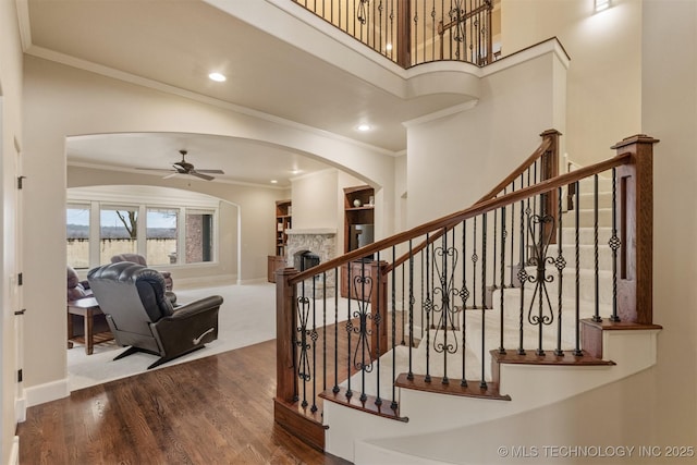 11870 S Oswego Ave, Tulsa, OK 74137 - stairway featuring arched walkways, ceiling fan, ornamental molding, wood finished floors, and a fireplace