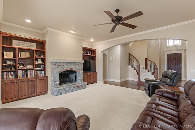 11870 S Oswego Ave, Tulsa, OK 74137 - living room with arched walkways, a ceiling fan, a stone fireplace, stairs, and ornamental molding