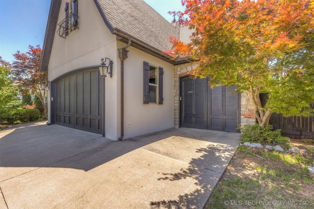 11870 S Oswego Ave, Tulsa, OK 74137 - view of side of property with a shingled roof, a garage, driveway, and stone siding