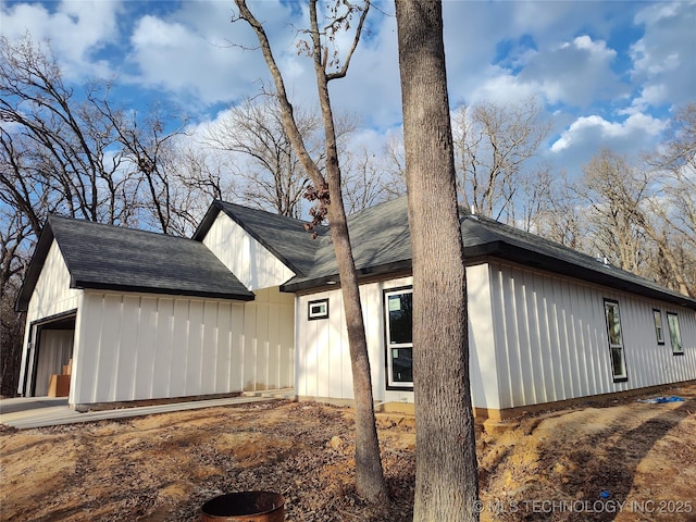 view of home's exterior with roof with shingles and board and batten siding