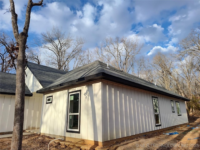 view of side of home featuring roof with shingles