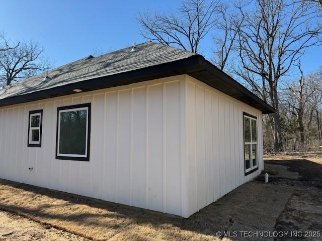 view of side of property featuring roof with shingles