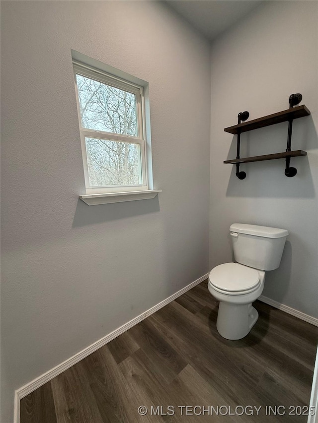 bathroom featuring toilet, baseboards, and wood finished floors