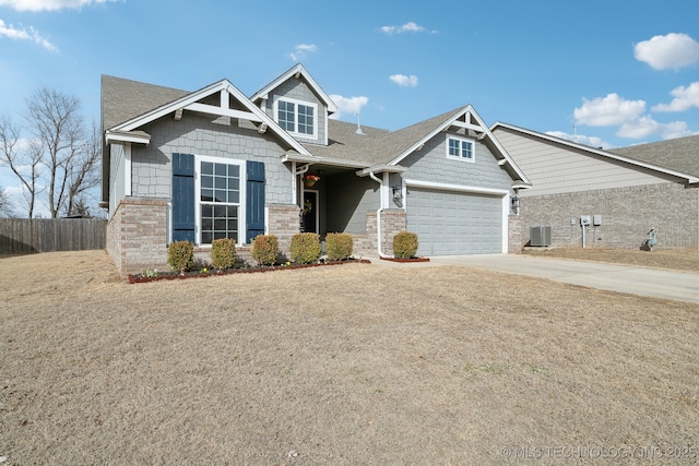 craftsman house with driveway, a shingled roof, an attached garage, and cooling unit