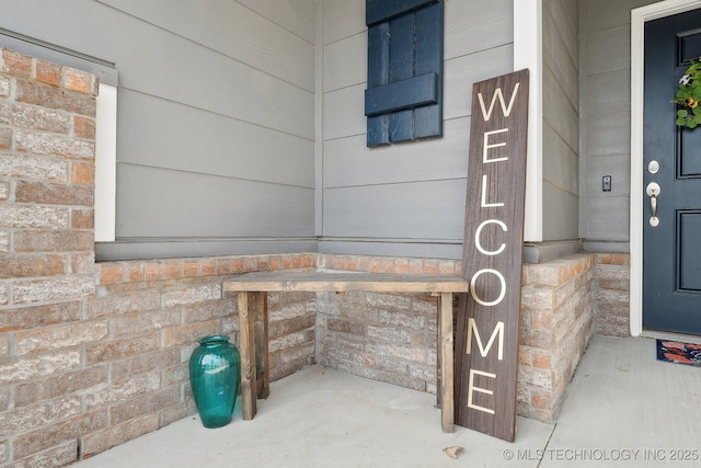 doorway to property featuring brick siding