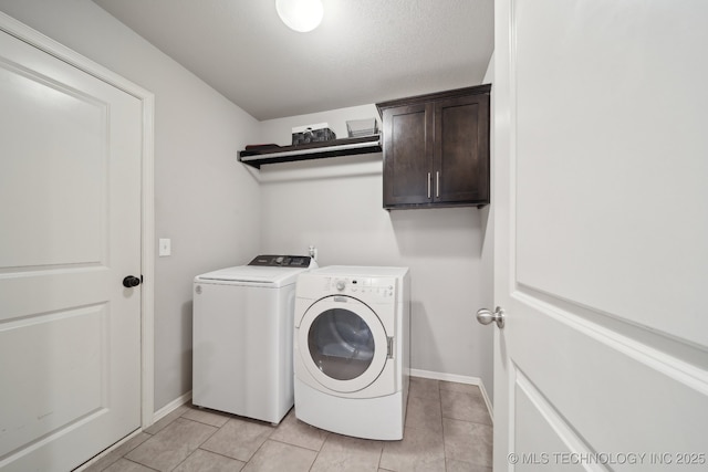 laundry room with light tile patterned floors, independent washer and dryer, cabinet space, and baseboards