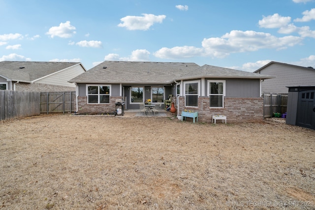 rear view of house with a fenced backyard, a patio, and brick siding